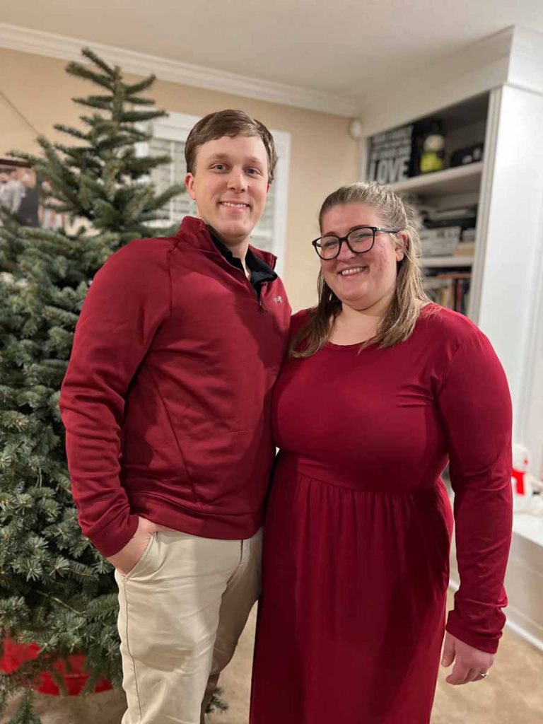 Owner of Paliulis Electric LLC smiling with his wife in front of a Christmas tree