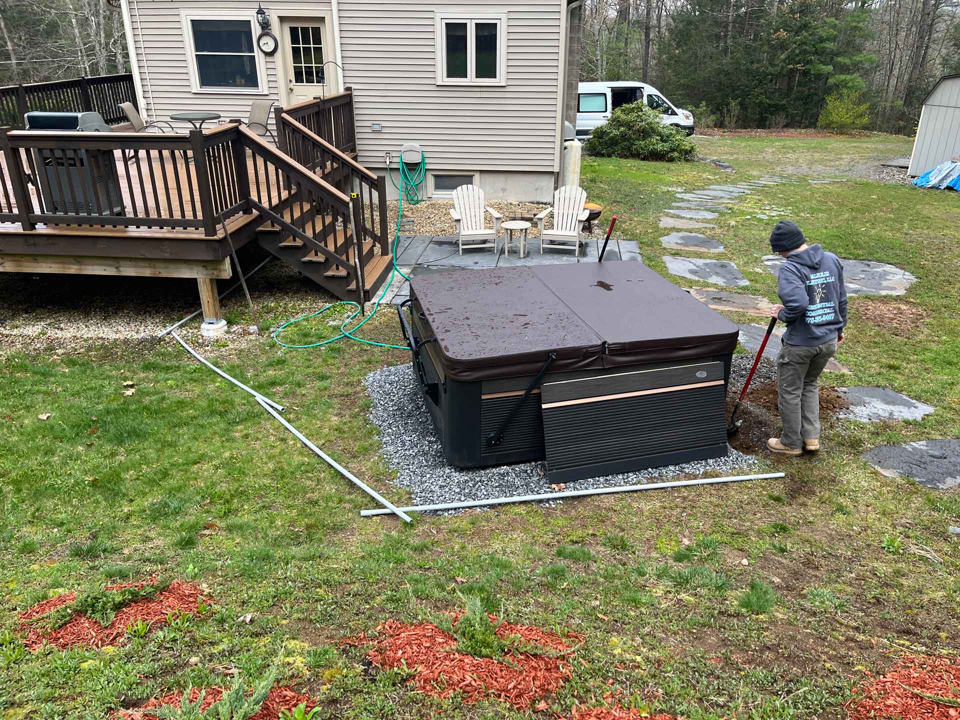 Electrician hooking up hot tub in backyard