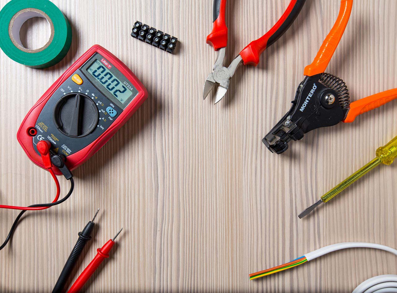 Electrician's tools scattered on wooden workbench