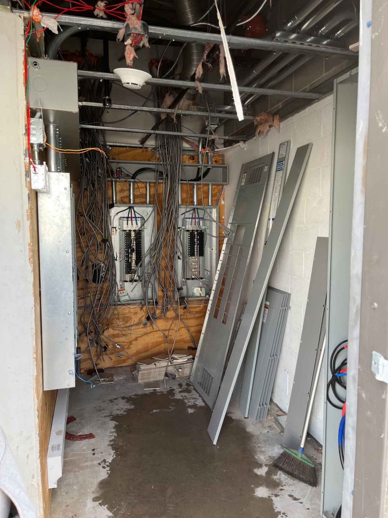 Small room with many electrical wires dangling from the ceiling